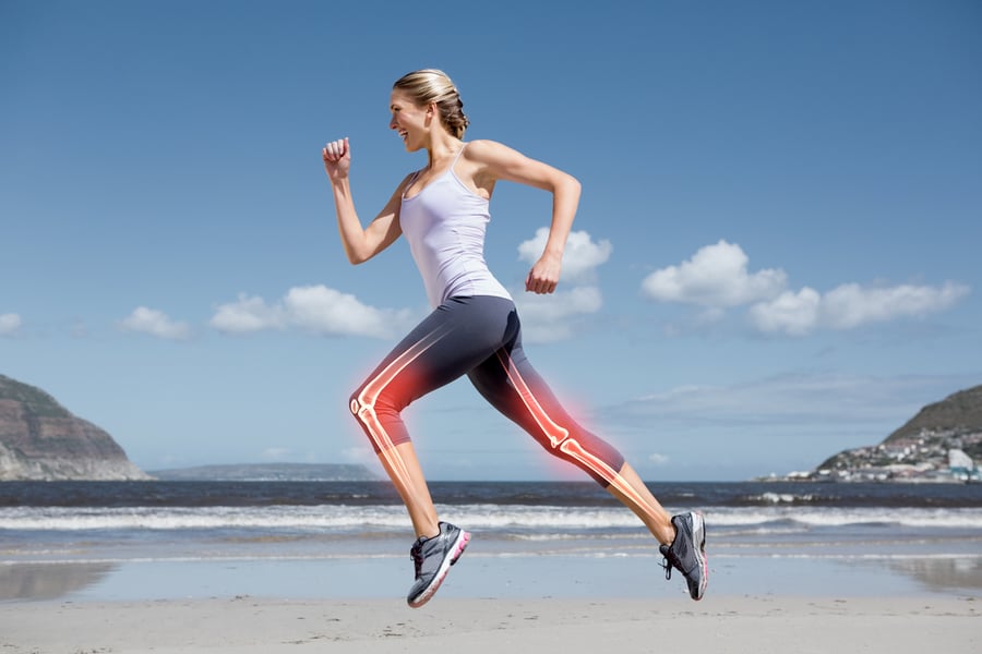 Digital composite of Highlighted leg bones of jogging woman on beach